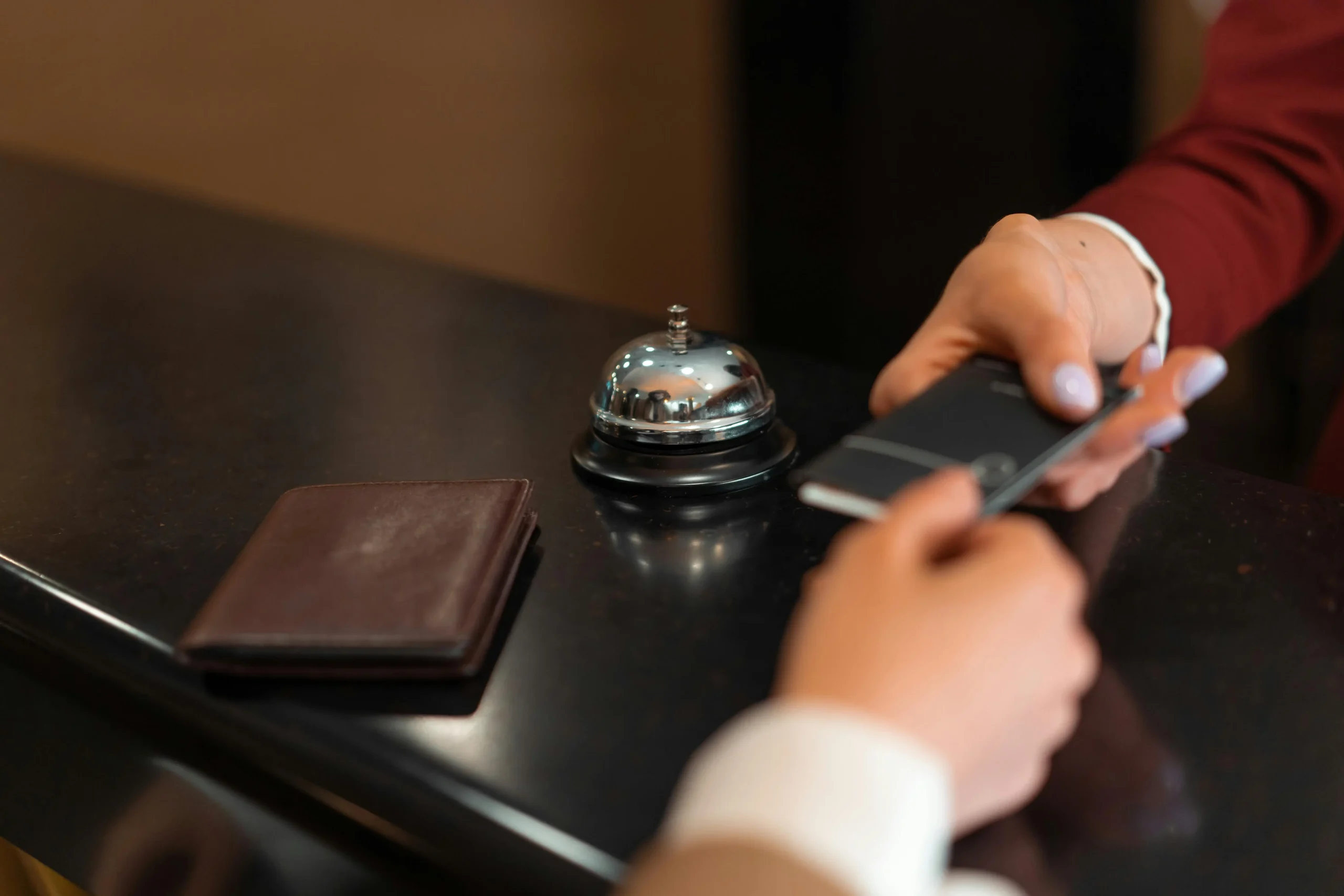 Person checking in at a hotel with a Marriott Bonvoy Bold Credit Card at the reception desk.